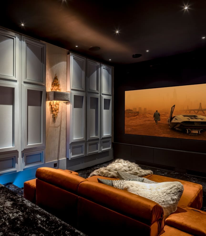 Luxe thuisbioscoop met een bruine bank, sfeerverlichting en een groot scherm waarop een scène uit Blade Runner 2049 speelt. Luxe thuisbioscoop met een bruine bank, sfeerverlichting en een groot scherm waarop een scène uit Blade Runner 2049 speelt.