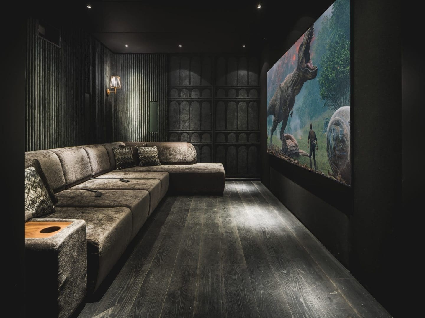 Luxe thuisbioscoop met een grote hoekbank en een scherm waarop een dinosaurus te zien is in Project Verde 0.3.
