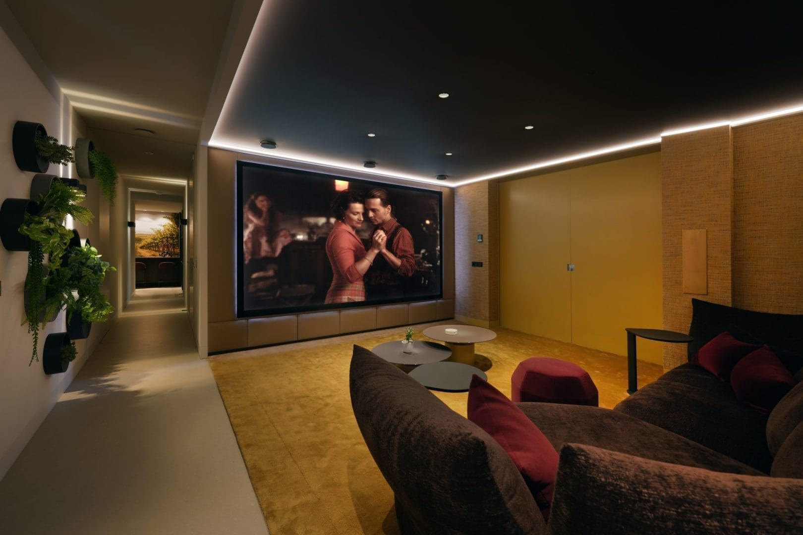 Luxe thuisbioscoop met een groot scherm waarop een dansend koppel te zien is, omringd door sfeervolle verlichting en planten. Luxe thuisbioscoop met een groot scherm waarop een dansend koppel te zien is, omringd door sfeervolle verlichting en planten.