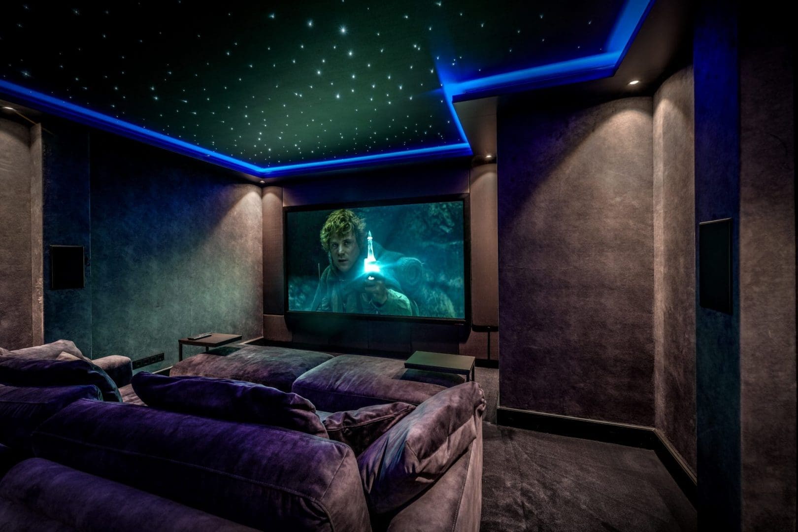 Luxury home cinema with purple seats, a starry sky ceiling, and a movie scene on the big screen titled *Project Noir 0.4* Luxury home cinema with purple seats, a starry sky ceiling, and a movie scene on the big screen titled *Project Noir 0.4*