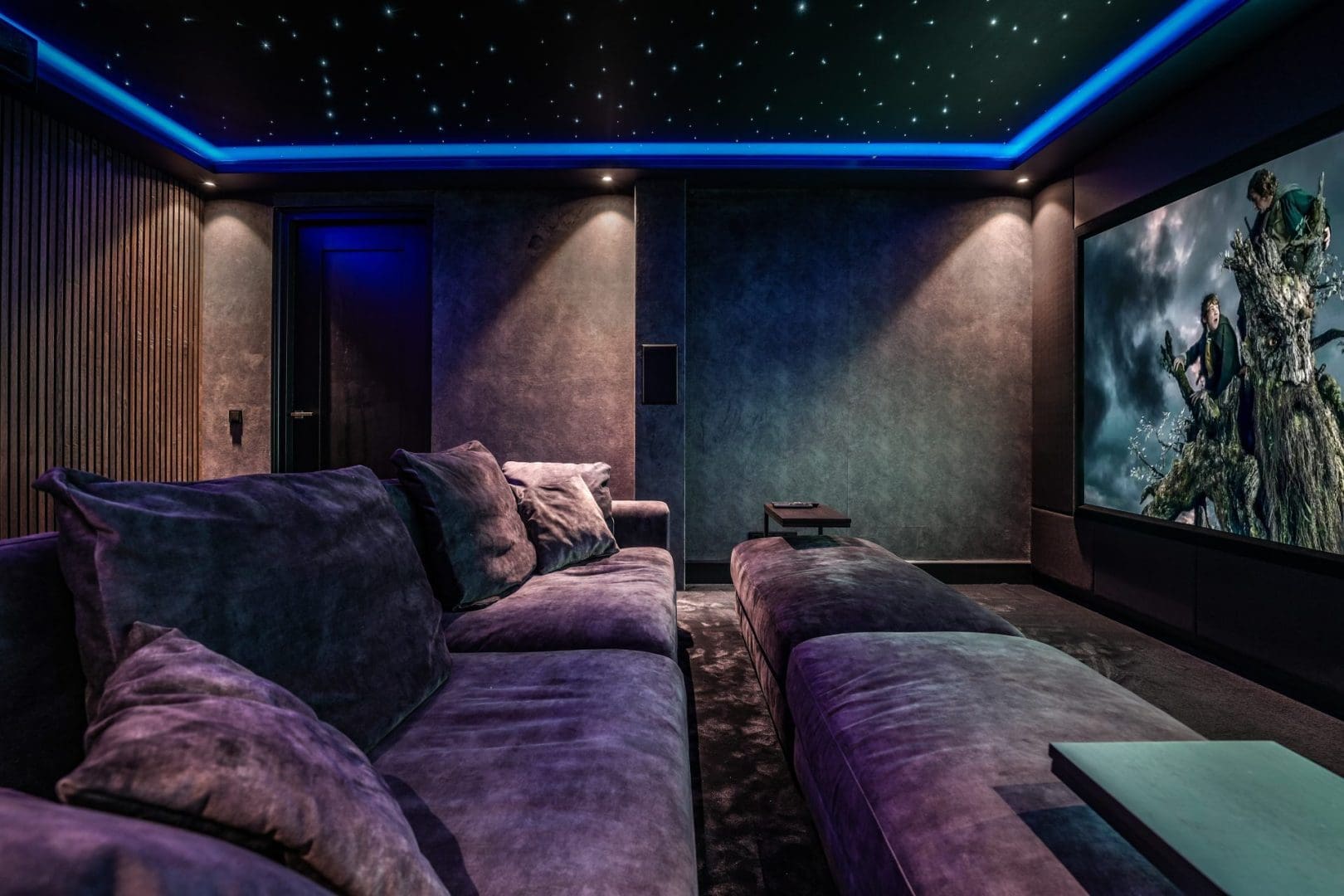 Luxe thuisbioscoop met een grote bank onder een sterrenhemelplafond en een filmscène op het grote scherm, Project Noir 0.2.