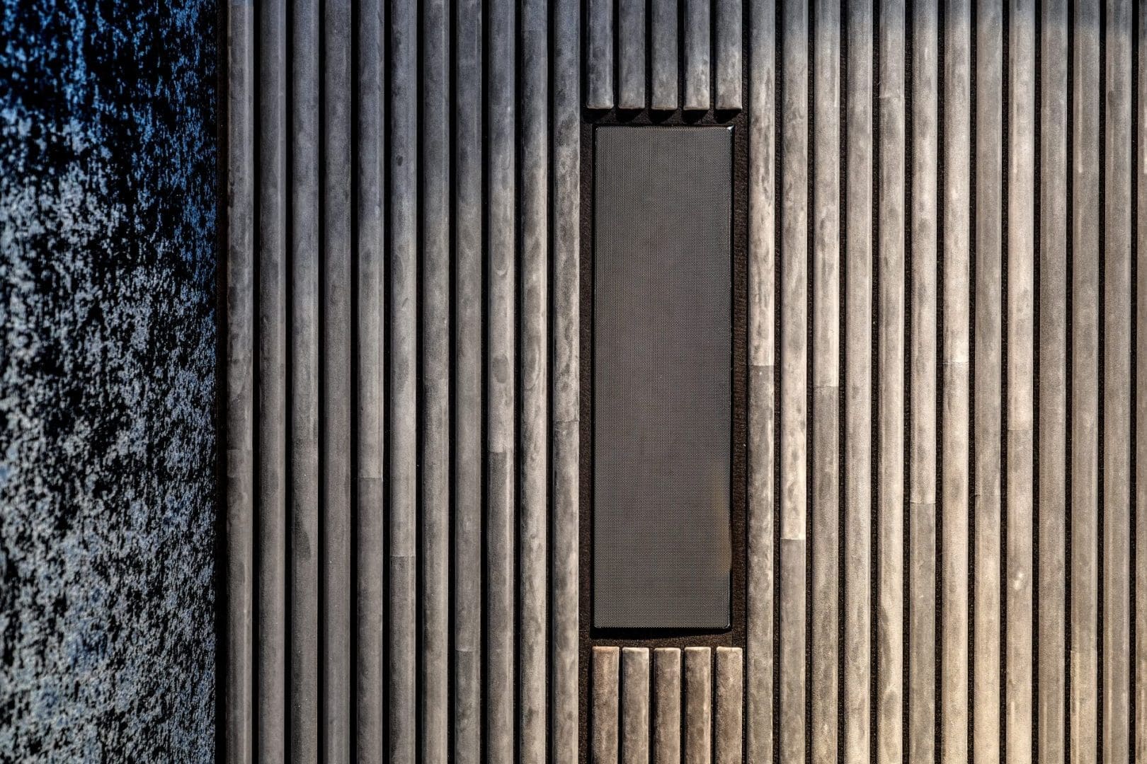 Verticaal gestreepte houten wand met een centraal rechthoekig paneel uit Project Onyx 0.5. Verticaal gestreepte houten wand met een centraal rechthoekig paneel uit Project Onyx 0.5.