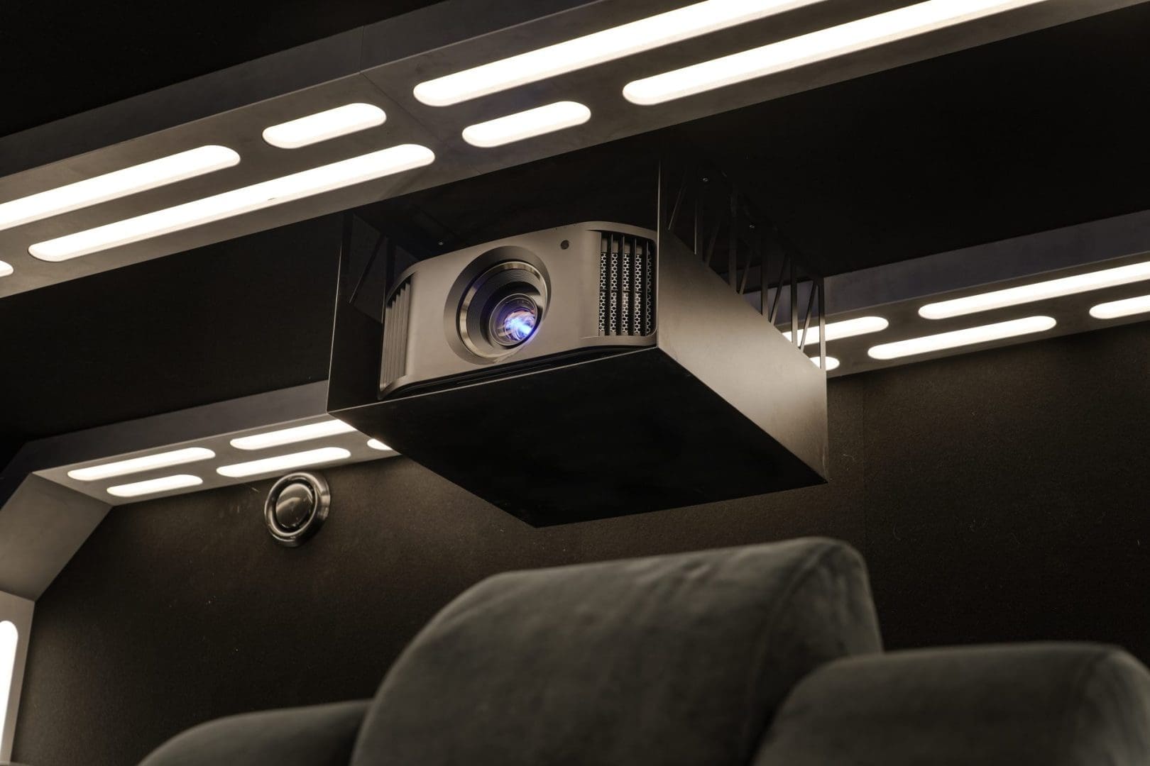 Een projector hangt aan een plafond met verlichte panelen in een thuisbioscoop genaamd Project Hyperspace 0.4. Een projector hangt aan een plafond met verlichte panelen in een thuisbioscoop genaamd Project Hyperspace 0.4.