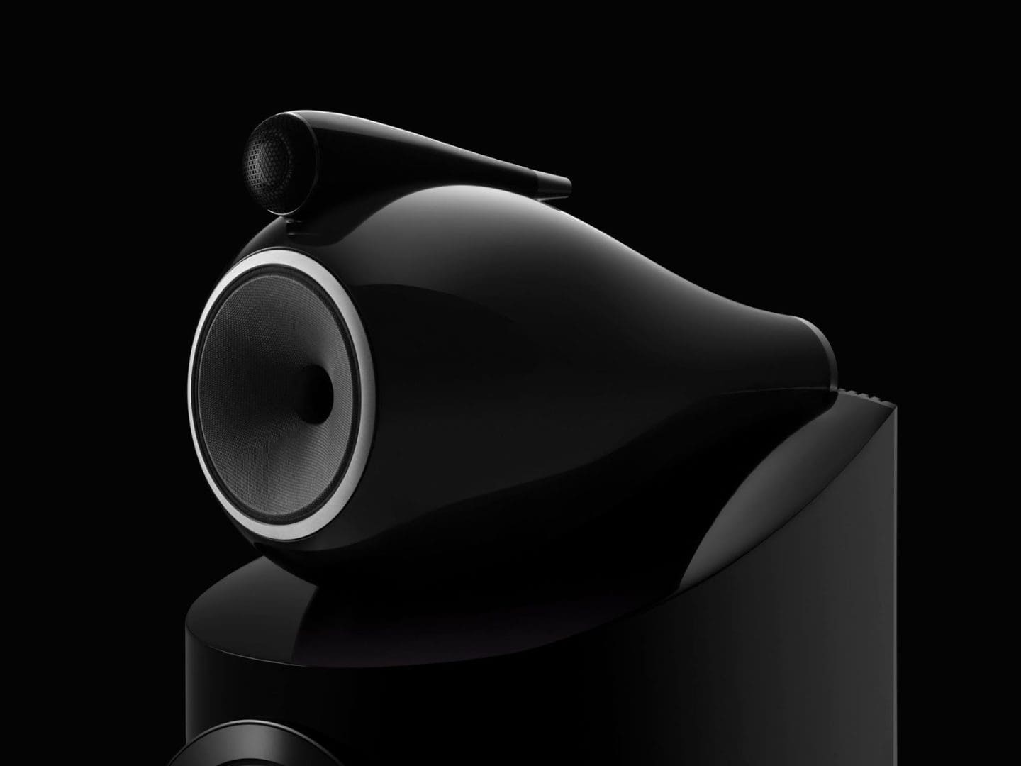 Glanzende zwarte Bowers & Wilkins luidspreker met een kenmerkende tweeter op een zwarte achtergrond. Glanzende zwarte Bowers & Wilkins luidspreker met een kenmerkende tweeter op een zwarte achtergrond.