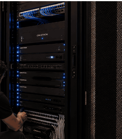 Technicus werkt aan een rack met Crestron-domotica-apparatuur en netwerkbekabeling. Technicus werkt aan een rack met Crestron-domotica-apparatuur en netwerkbekabeling.